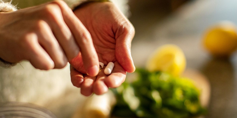 Afbeelding van foto van hand met vitamines en groenten