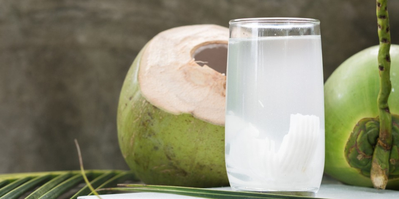 Image of photo of coconuts with a glass of coconut water