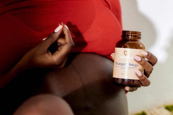 photo of a pregnant woman with an omega supplement