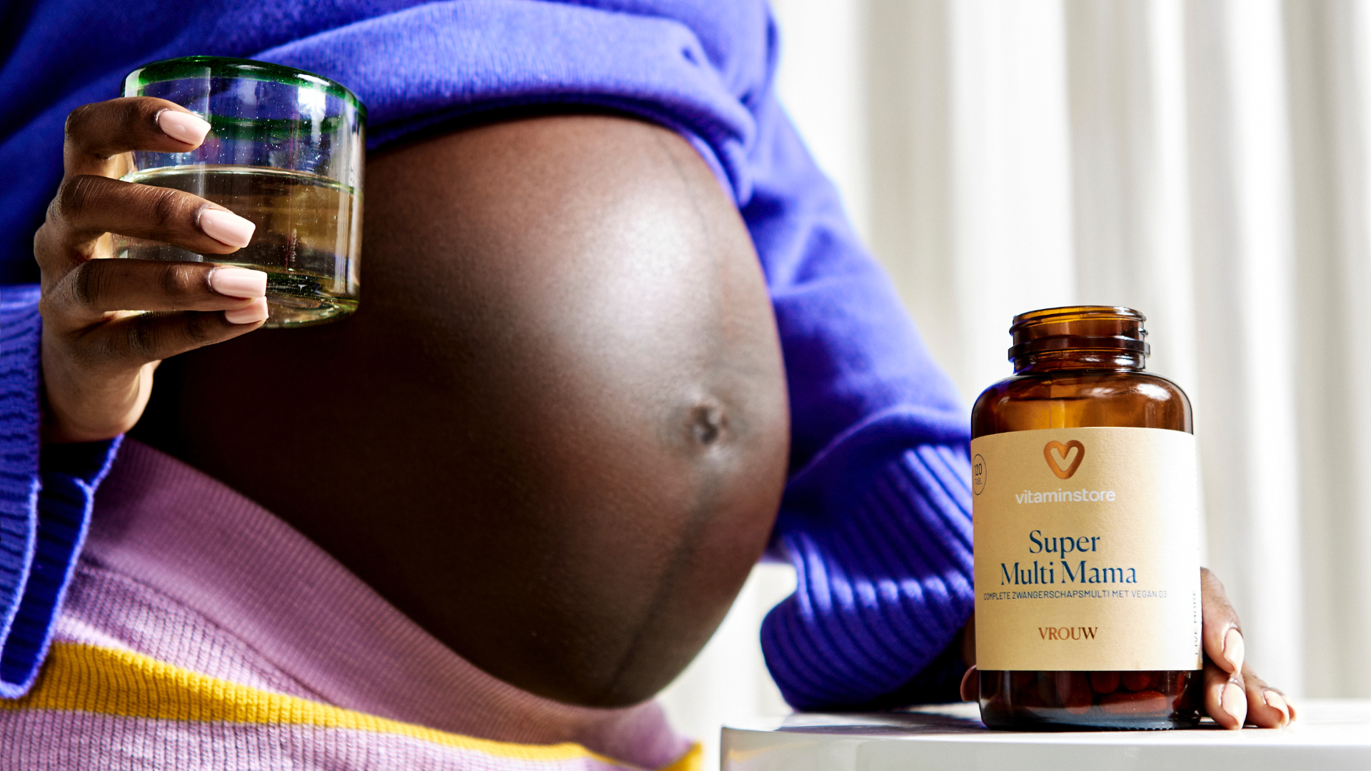 photo of a pregnant woman with an omega supplement