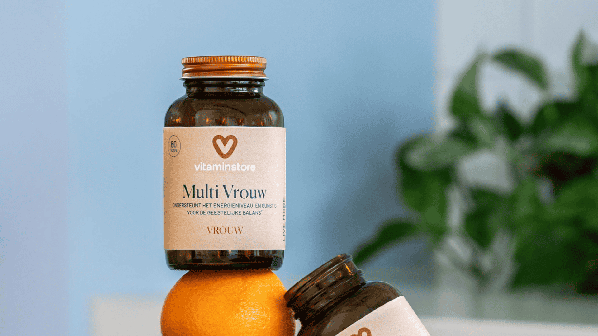 Foto eines Vitamin-Glases für Frauen auf einer Orange in einer Küchenszene